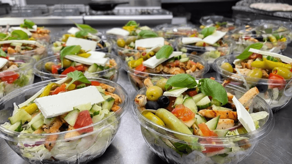Gemischter griechischer Salat in einer Glasschale mit Feta